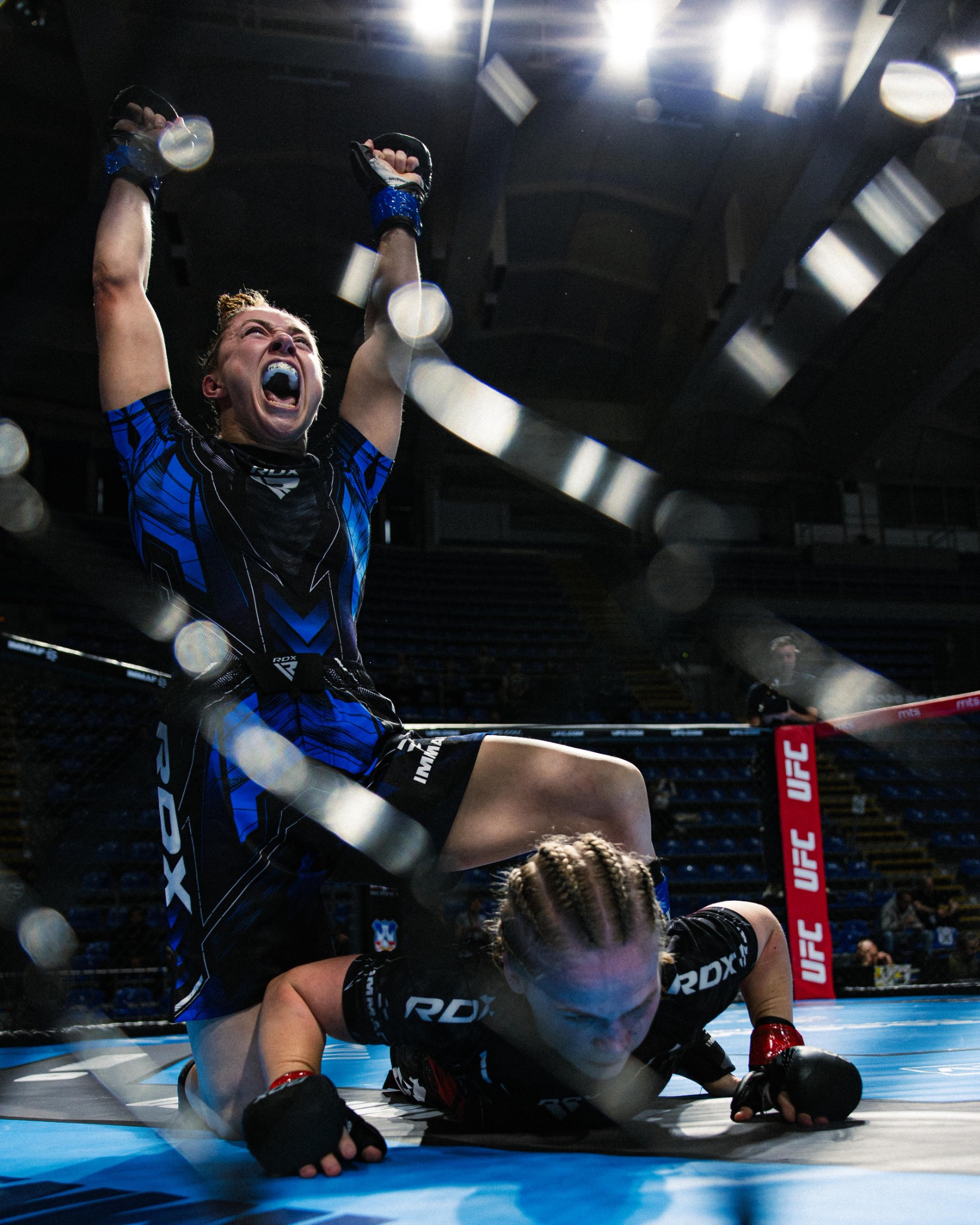 Katrina Fisher celebrating an intense finishing moment inside the cage