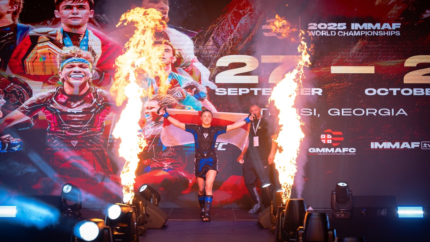 Katrina Fisher walking towards the cage through lights and flames